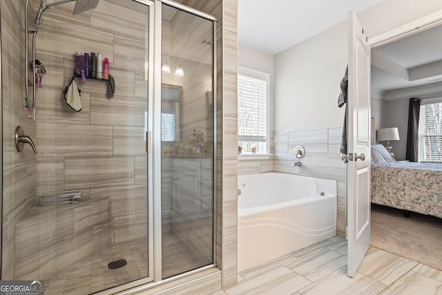 bathroom with shower with separate bathtub, plenty of natural light, and tile walls