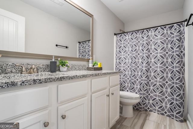 bathroom with a shower with curtain, vanity, and toilet