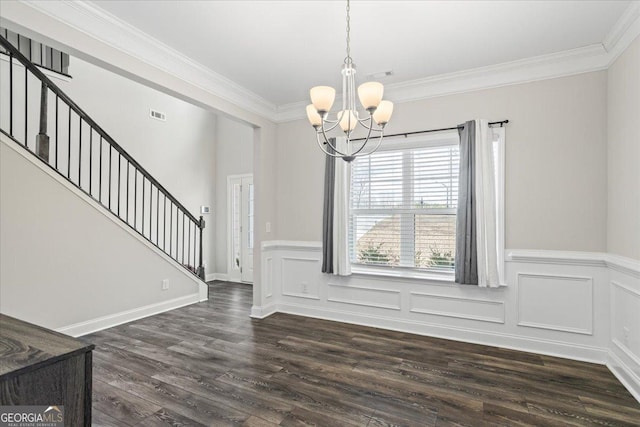 unfurnished dining area featuring an inviting chandelier, dark hardwood / wood-style flooring, and ornamental molding