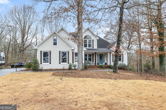 view of property with a porch and a front lawn