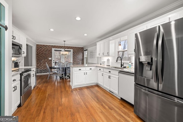 kitchen with white cabinetry, sink, decorative light fixtures, and appliances with stainless steel finishes