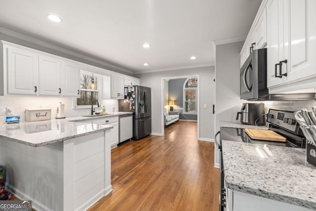 kitchen featuring stainless steel appliances, light stone countertops, sink, and white cabinets