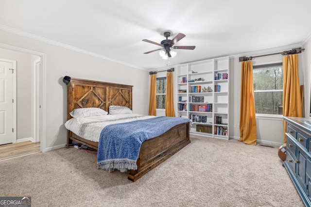 carpeted bedroom featuring crown molding and ceiling fan