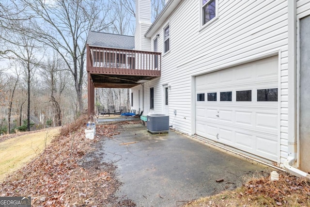 view of home's exterior with a wooden deck, a garage, and central AC