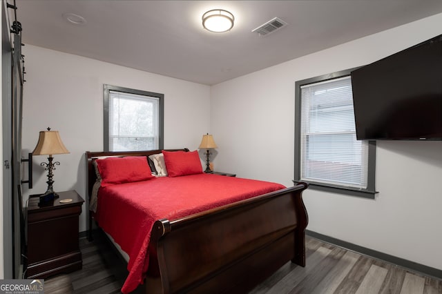 bedroom with dark hardwood / wood-style floors