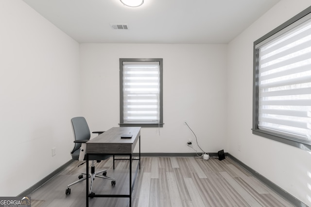 home office featuring a healthy amount of sunlight and light wood-type flooring