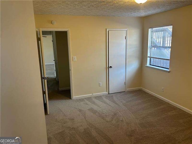 unfurnished bedroom with light colored carpet and a textured ceiling