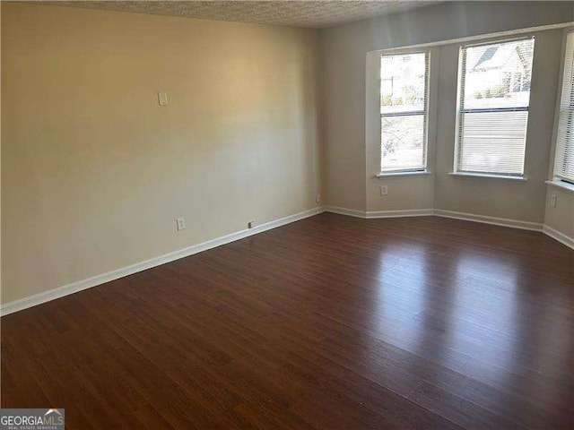 unfurnished room featuring dark hardwood / wood-style floors and a textured ceiling