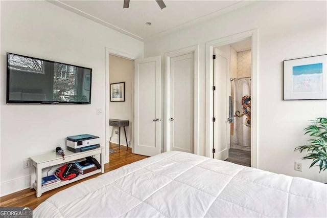 bedroom featuring connected bathroom, hardwood / wood-style floors, and ceiling fan