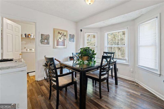 dining space with washer / clothes dryer, dark hardwood / wood-style floors, and a textured ceiling