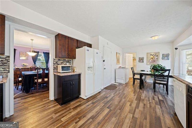 kitchen featuring backsplash, white appliances, dark wood-type flooring, and decorative light fixtures