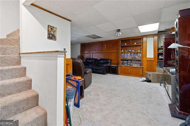 interior space with a paneled ceiling and light colored carpet