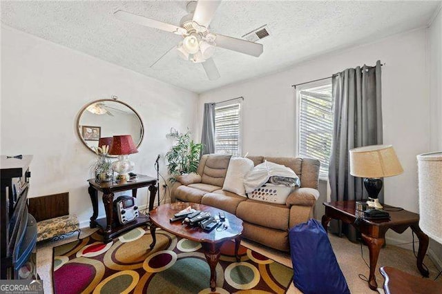 carpeted living room with ceiling fan and a textured ceiling