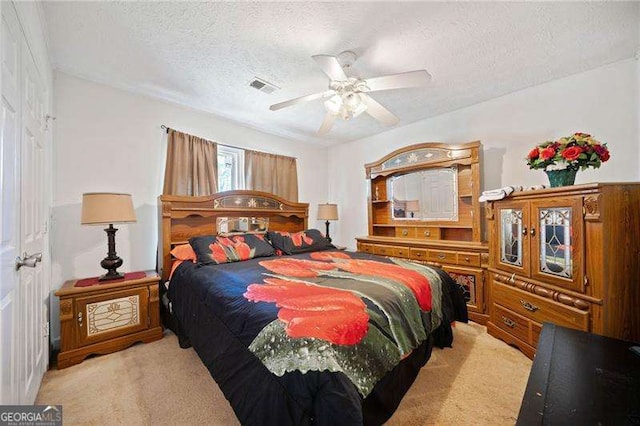 carpeted bedroom featuring ceiling fan and a textured ceiling