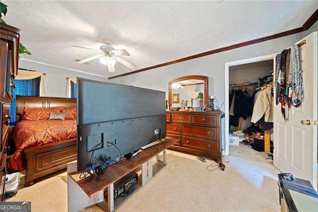 carpeted bedroom featuring ceiling fan, ornamental molding, a textured ceiling, a walk in closet, and a closet