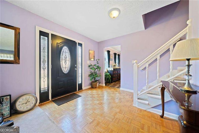 entrance foyer featuring a textured ceiling and light parquet floors