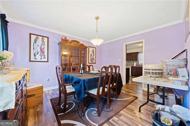 dining space with crown molding and wood-type flooring