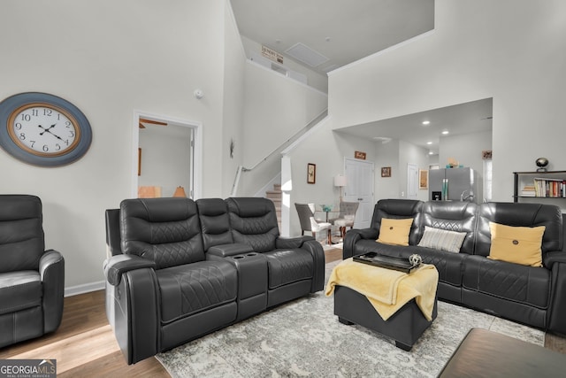 living room with a high ceiling and wood-type flooring