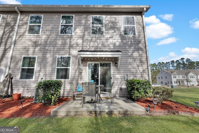 back of house with a patio area and a lawn