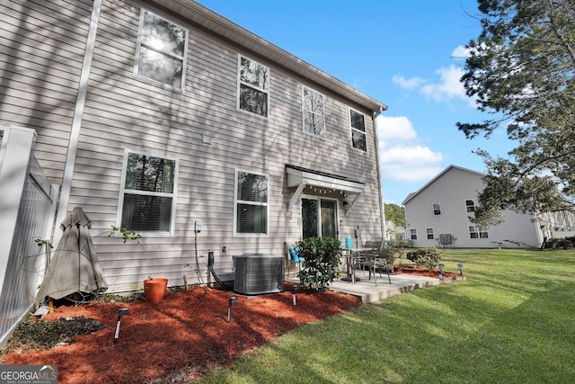 rear view of property with a lawn, a patio, and central air condition unit