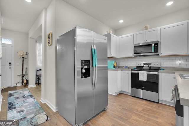 kitchen with white cabinetry, appliances with stainless steel finishes, and backsplash