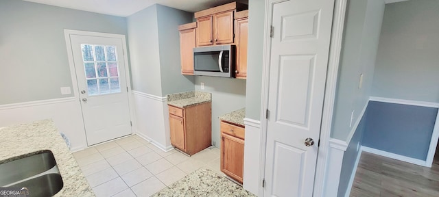 kitchen featuring light stone countertops, sink, and light tile patterned floors