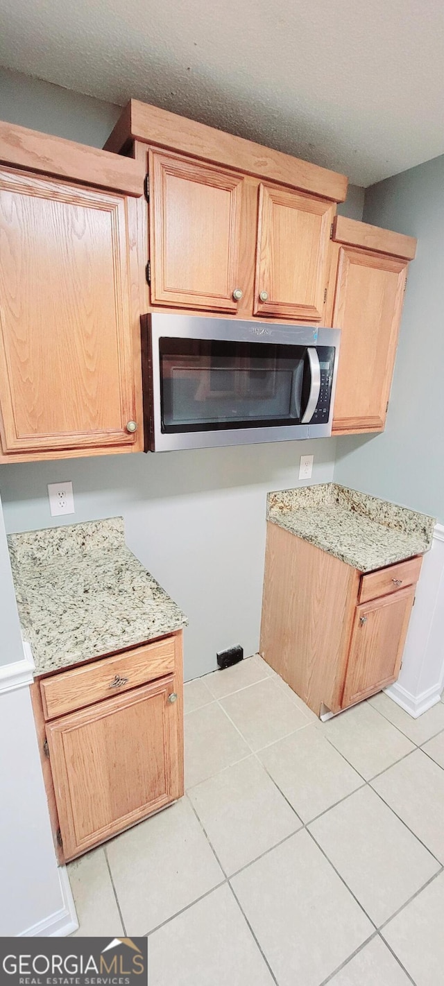 kitchen with light stone countertops and light tile patterned floors