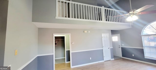 spare room featuring a high ceiling, ceiling fan, and light hardwood / wood-style floors