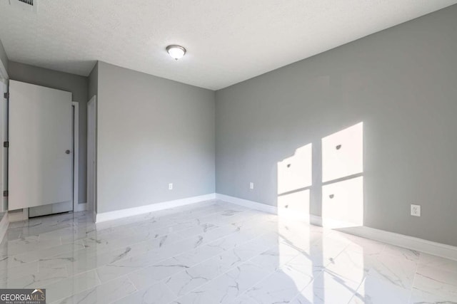 spare room with a textured ceiling