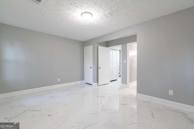 unfurnished room with a textured ceiling