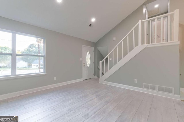 unfurnished living room with vaulted ceiling and light hardwood / wood-style flooring