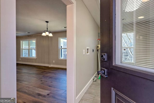 entryway with hardwood / wood-style flooring and a notable chandelier