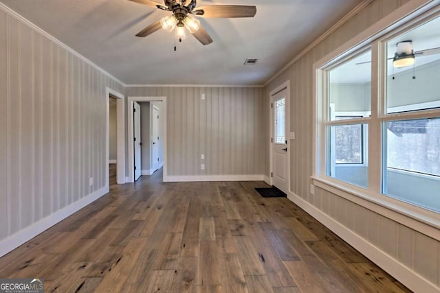 spare room with crown molding, dark wood-type flooring, and ceiling fan