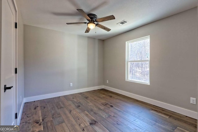 spare room with dark wood-type flooring and ceiling fan