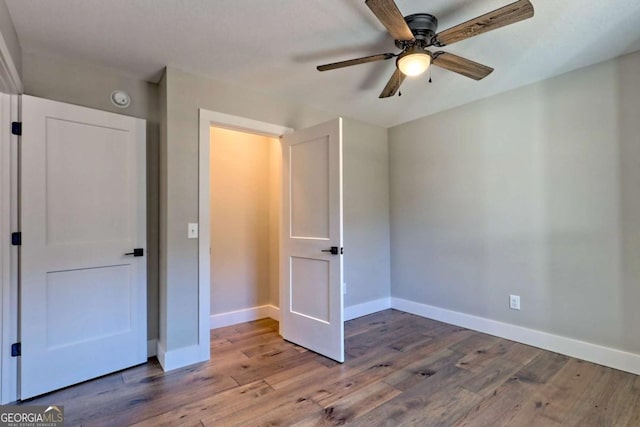 unfurnished bedroom featuring hardwood / wood-style floors and ceiling fan