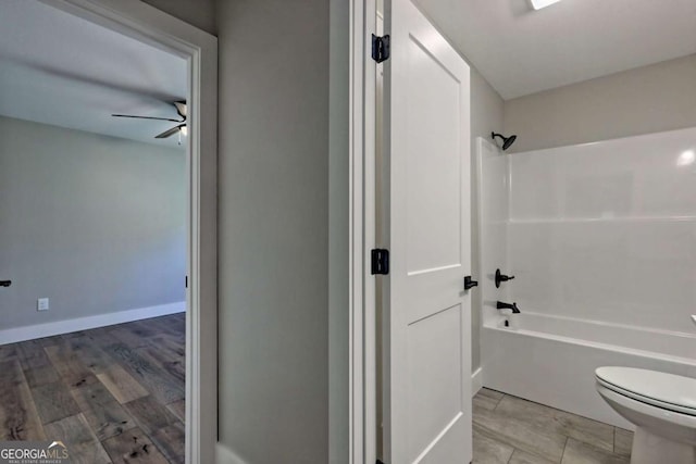 bathroom featuring ceiling fan, wood-type flooring, toilet, and shower / bath combination