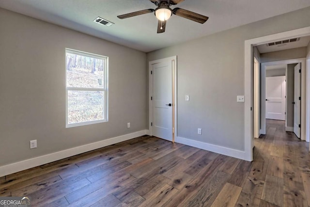 unfurnished bedroom with ceiling fan and dark hardwood / wood-style flooring