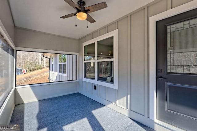 unfurnished sunroom featuring ceiling fan