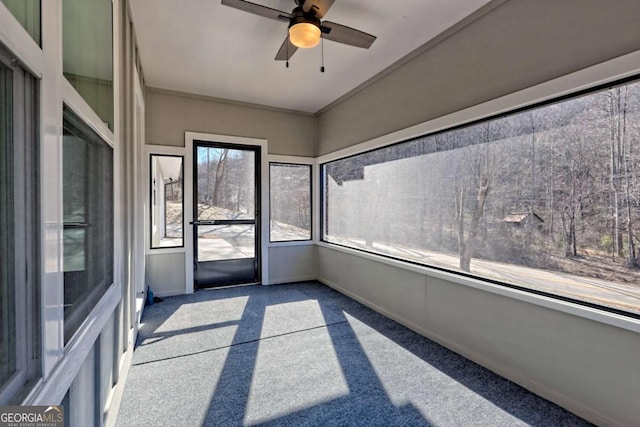 unfurnished sunroom featuring ceiling fan