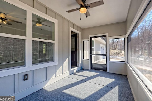 unfurnished sunroom featuring a healthy amount of sunlight and ceiling fan