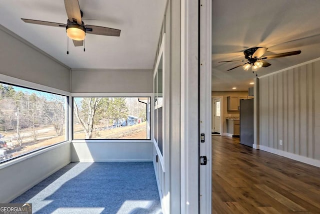 unfurnished sunroom with ceiling fan