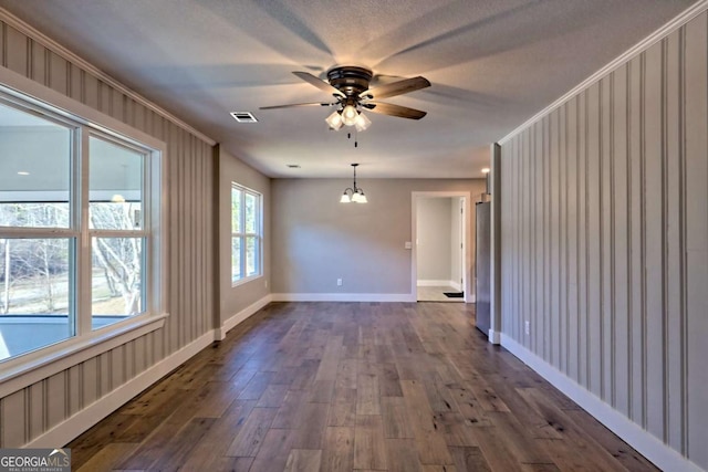 empty room featuring dark hardwood / wood-style floors and ceiling fan with notable chandelier