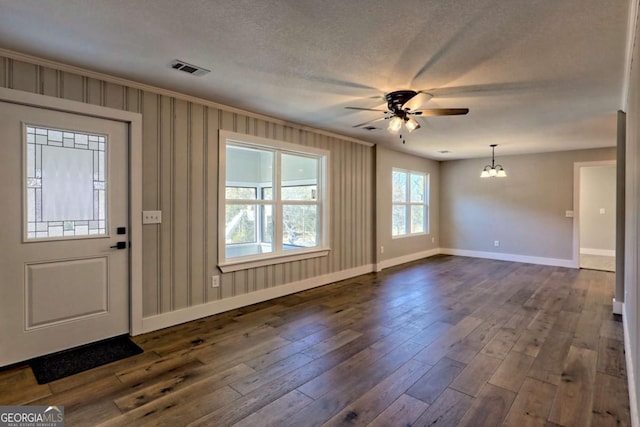 foyer entrance featuring crown molding, dark hardwood / wood-style floors, ceiling fan with notable chandelier, and a textured ceiling