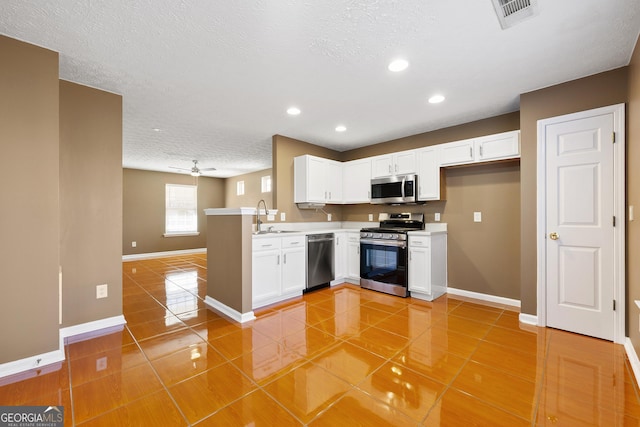 kitchen with light tile patterned flooring, stainless steel appliances, sink, and white cabinets