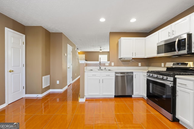 kitchen featuring white cabinetry, stainless steel appliances, light tile patterned flooring, and sink