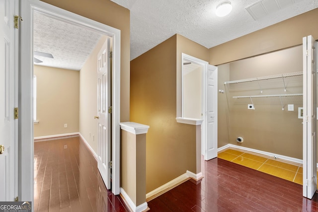 hallway with dark hardwood / wood-style flooring and a textured ceiling