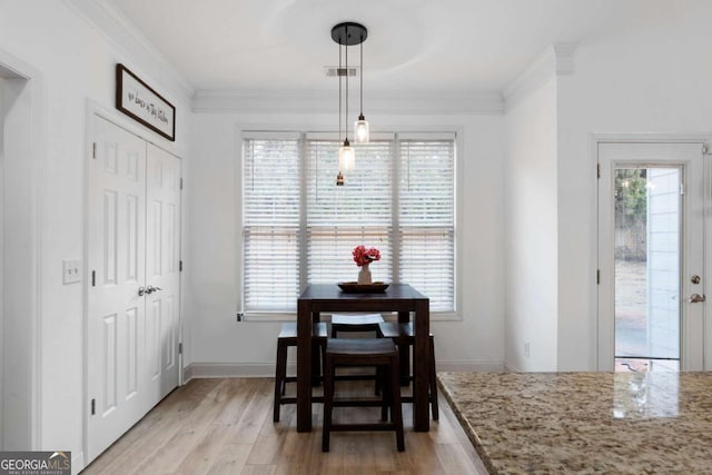 dining area featuring ornamental molding, light hardwood / wood-style floors, and plenty of natural light