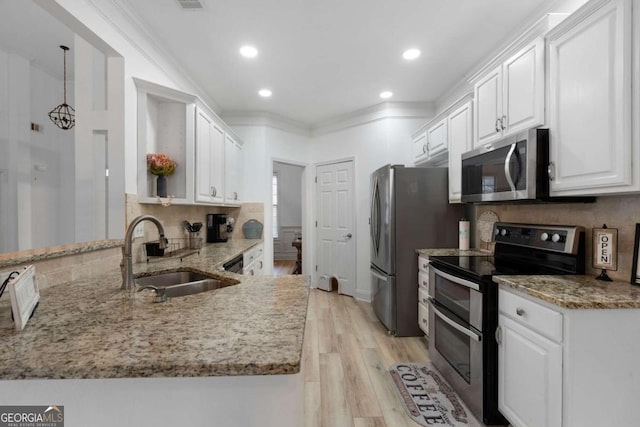 kitchen with appliances with stainless steel finishes, sink, white cabinets, and kitchen peninsula