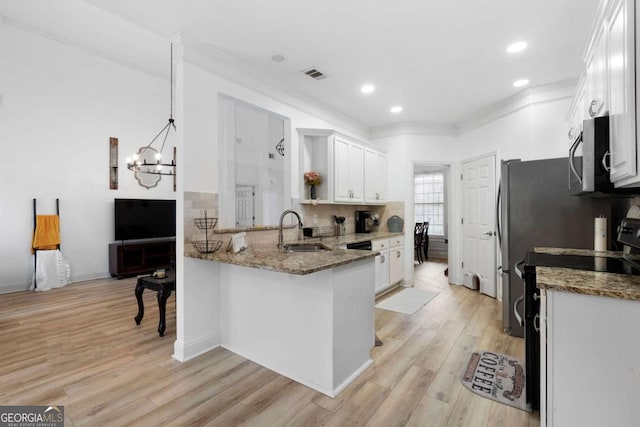 kitchen with white cabinetry, pendant lighting, and dark stone counters