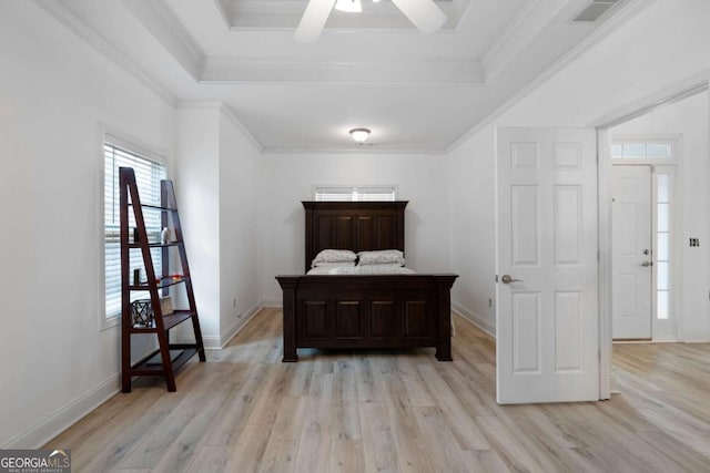 bedroom featuring crown molding, ceiling fan, a tray ceiling, and light wood-type flooring